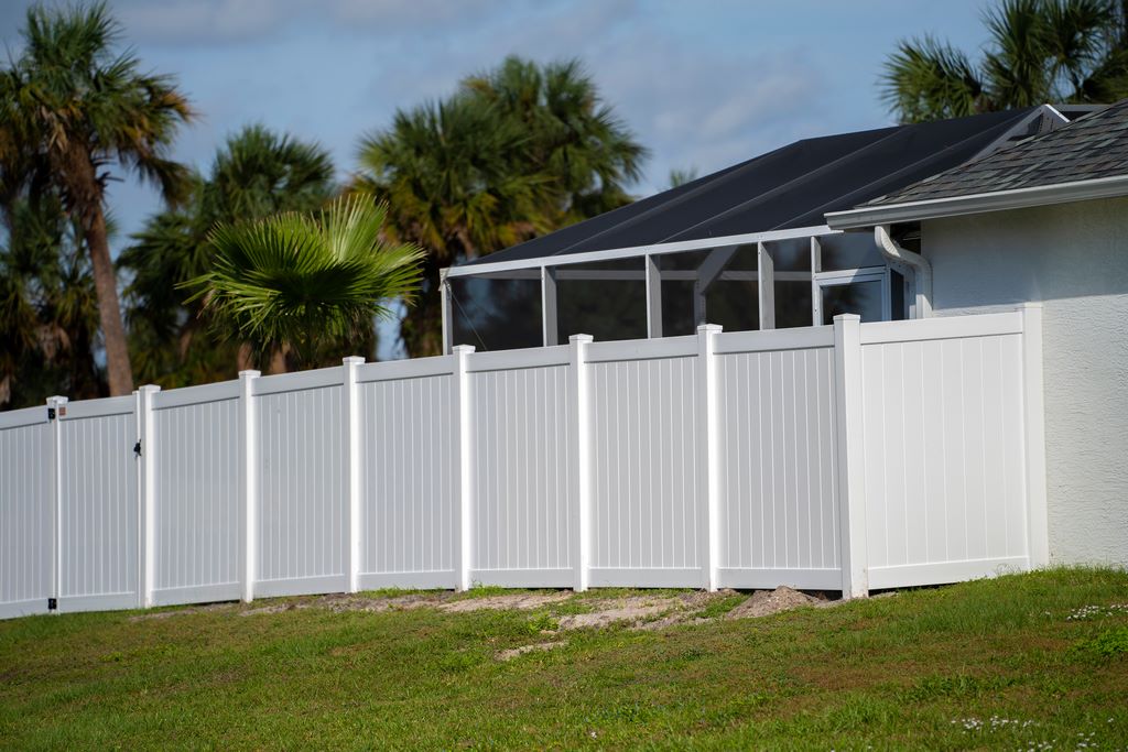 White vinyl fence with palm trees in Clearwater, FL